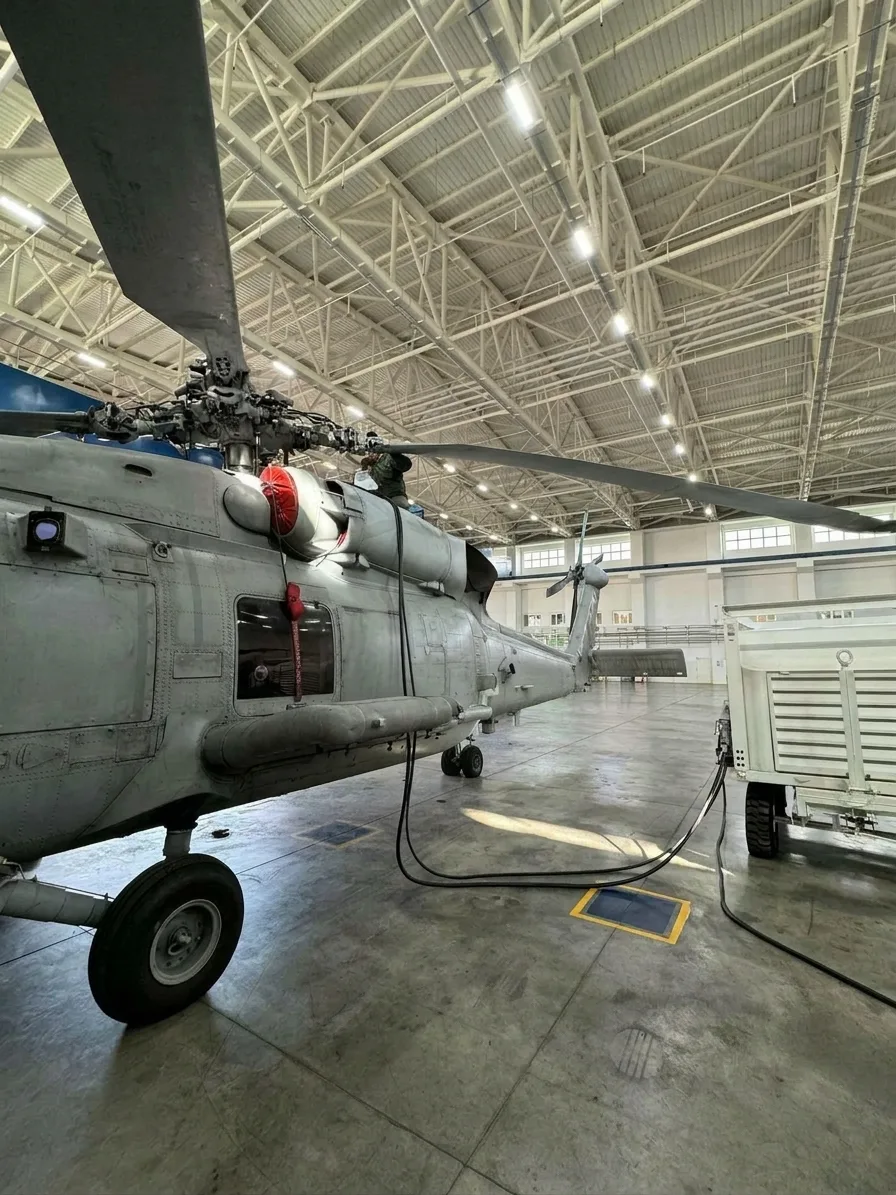 Hydraulic power unit connected to a helicopter in a hangar